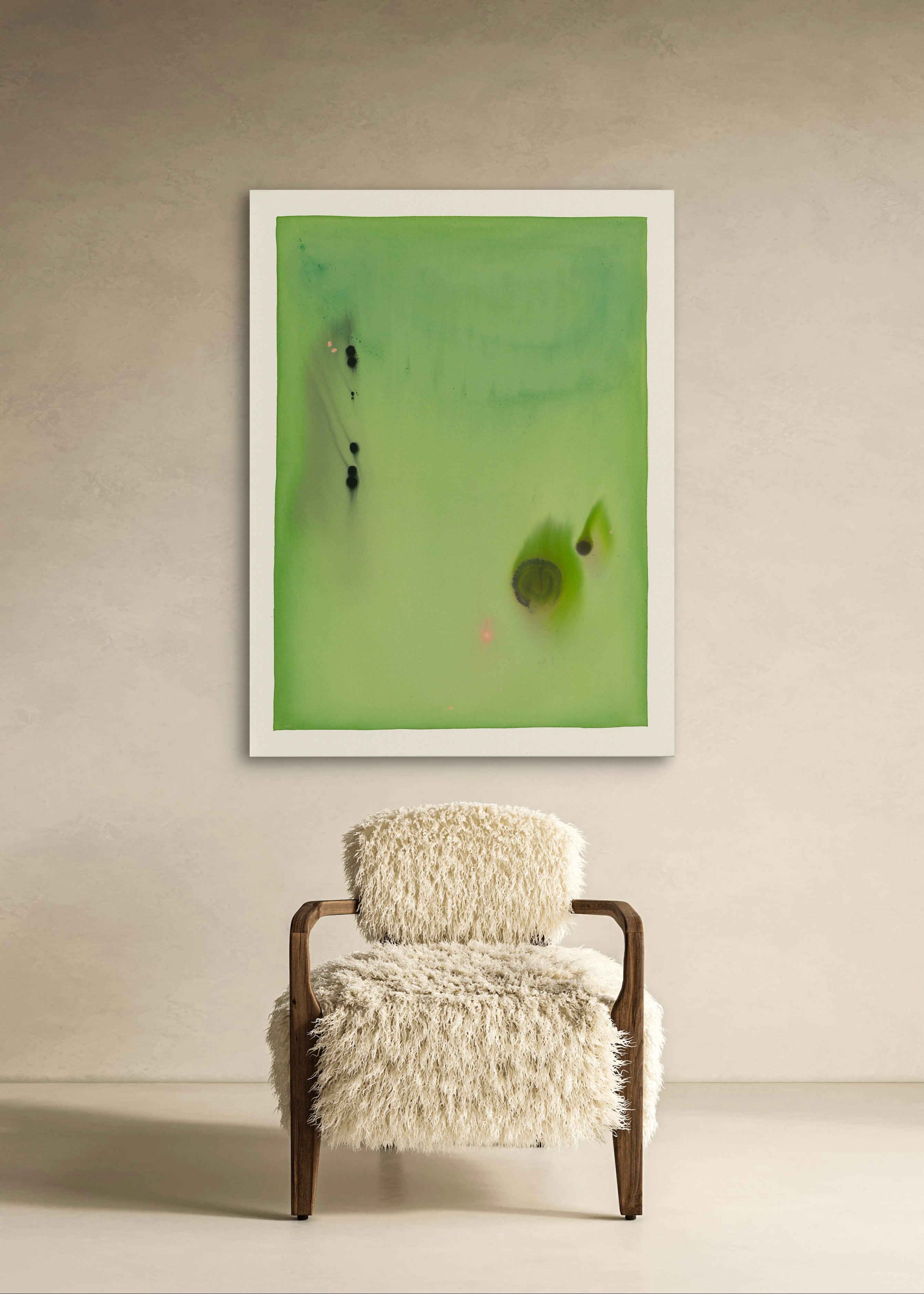 Abstract artwork on a wall above a chair with a fluffy cushion.