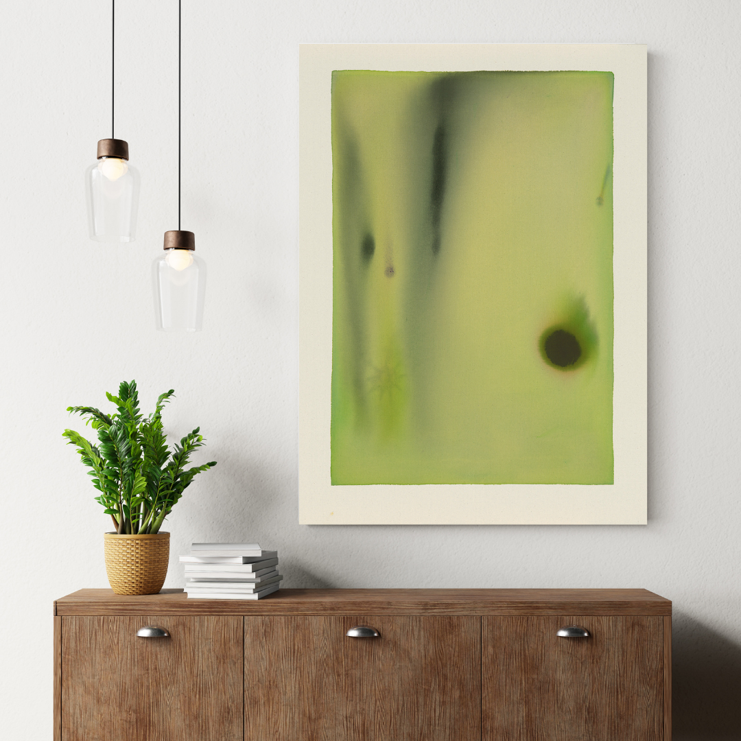 Abstract art piece on a wall above a wooden cabinet with a plant and books.