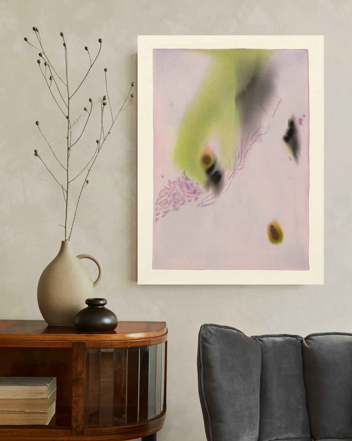 Abstract art piece on a wall above a wooden console table with decorative items.