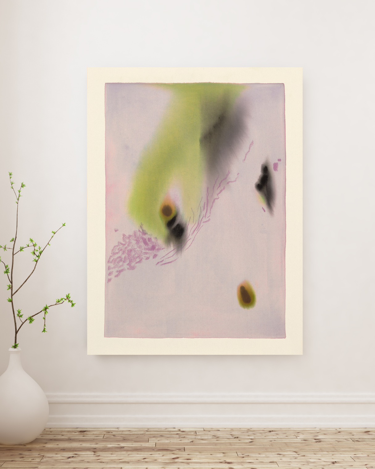 Abstract art piece on a white wall with a vase and branch in the foreground.